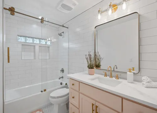 A luxurious, newly renovated bathroom featuring modern fixtures and stylish finishes by JH Midland Builder.